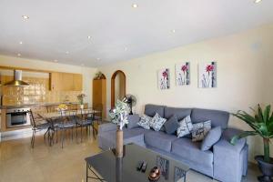 a living room with a blue couch and a kitchen at Villa Tazana in Icod de los Vinos