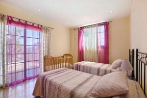 two beds in a bedroom with red curtains at Villa Tazana in Icod de los Vinos +17 photos