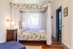 a bedroom with a canopy bed and a window at Birbina - Poggio alle Birbe in Il Bagno