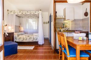 a kitchen and dining room with a table and a bed at Birbina - Poggio alle Birbe in Il Bagno