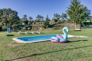 a swimming pool with a swan in the grass at Can Palau in Agullana