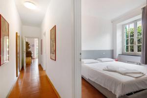 a white bedroom with a bed and a window at Via Colombo 12 - Trilocale in Bonassola