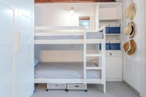 a white bunk room with two bunk beds at Sunrise Medes in Torroella de Montgrí