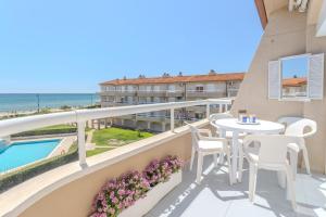 a balcony with a table and chairs and a view of the ocean at Sunrise Medes in Torroella de Montgrí +14 photos