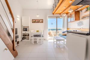 a kitchen and living room with a view of the ocean at Sunrise Medes in Torroella de Montgrí