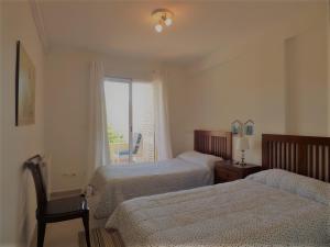 a hotel room with two beds and a window at Ático en Jávea - Solo Familias 1813 in Platja de l'Arenal