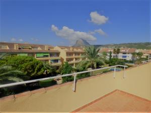 a balcony with a view of a building and trees at Ático en Jávea - Solo Familias 1813 in Platja de l'Arenal