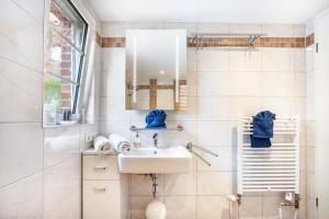 a white bathroom with a sink and a mirror at Deichkate Deichwinkel in Drochtersen +14 photos