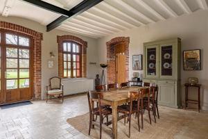 a dining room with a wooden table and chairs at Les Ecuries - La Trigalière in Ambillou