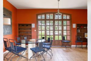 a dining room with orange walls and a table and chairs at Les Ecuries - La Trigalière in Ambillou +24 photos