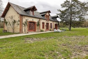 a large house with a grass field in front of it at Les Ecuries - La Trigalière in Ambillou