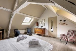 a bedroom with a bed and a desk and a window at Les Ecuries - La Trigalière in Ambillou
