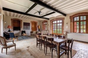 a large living room with a table and chairs at Les Ecuries - La Trigalière in Ambillou