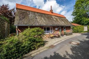 a small brick house with an orange roof at Deichkate Deichwinkel in Drochtersen