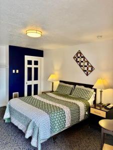 a bedroom with a large bed and blue walls at Motel West in Bend