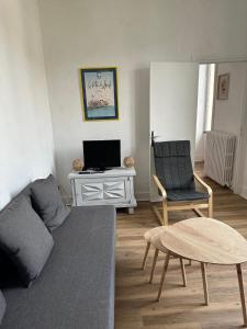 a living room with a couch and a table at Appartement 16 colette in La Bourboule