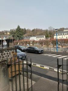 a parking lot with cars driving down a street at Appartement 16 colette in La Bourboule