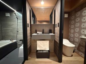 a bathroom with a sink and a toilet and a tub at Hatagoyorozu in Sasebo