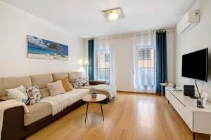 a living room with a couch and a tv at Ria Formosa Pool Heaven in Olhão