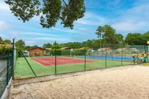 a tennis court with two tennis courts at Chalet A Village Vacances in Gujan-Mestras