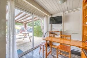 a dining room with a table and a sliding glass door at Chalet A Village Vacances in Gujan-Mestras