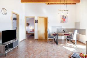 a living room with a television and a table and chairs at Obstgut Mit Herz Thomas Maier in Stockach