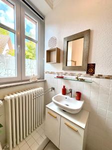 a bathroom with a sink and a radiator and a mirror at Schlafen im historischen Haus in Weier +27 photos