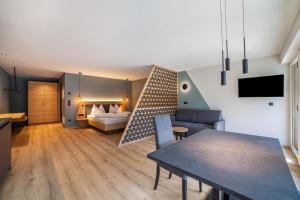 a living room with a dining table and a bedroom at Aktiv Lodge Meran - Garden Two in San Martino