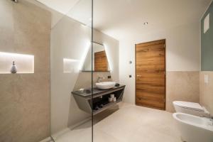 a bathroom with a sink and a toilet and a mirror at Aktiv Lodge Meran - Garden Two in San Martino +35 photos