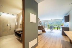 a kitchen and living room with a view of a dining room at Aktiv Lodge Meran - Garden Two in San Martino