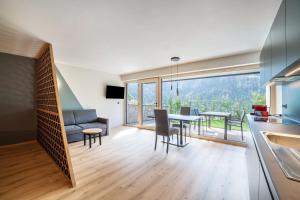 a kitchen and living room with a table and a couch at Aktiv Lodge Meran - Garden Two in San Martino