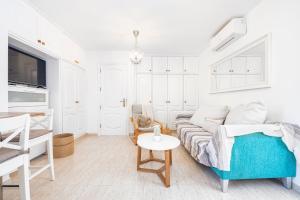 a white living room with a couch and a table at Pomelo vacacional in Arguineguín +27 photos
