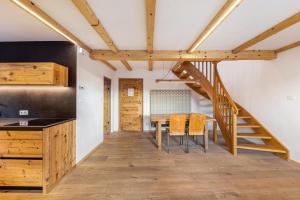 a kitchen and dining room with a wooden staircase and a table at Naturoase Stegerhof Apt Ringelblume in Trodena
