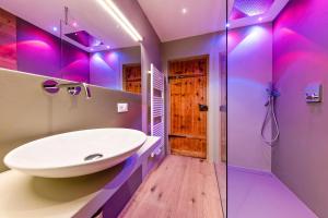 a bathroom with a sink and a shower with purple lighting at Naturoase Stegerhof Apt Ringelblume in Trodena +32 photos