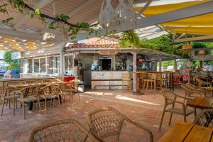 a restaurant with tables and chairs and a bar at Alex bar apartments in Parga