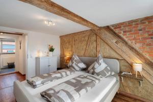 a bedroom with a white bed and a brick wall at Erlebnis-Bauernhof Scheunenglück in Oberkirch