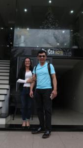 a man and a woman standing in front of a building at BeSea Hotel in Danang