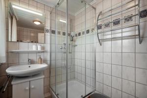 a bathroom with a glass shower and a sink at Ferienwohnung Carlina in Pfronten +20 photos