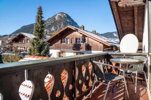 a balcony with a table and chairs and a mountain at Ferienwohnung Carlina in Pfronten