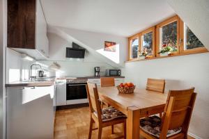 a kitchen with a wooden table and chairs at Ferienwohnung Carlina in Pfronten