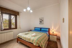 a white bedroom with a bed and a window at Villa Salento in Cellino San Marco