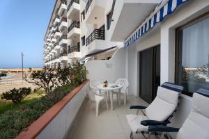 a balcony of a building with a table and chairs at Carpediem Playa La Arena in Puerto de Santiago