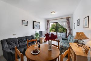 a living room with a table and a couch at Carpediem Playa La Arena in Puerto de Santiago