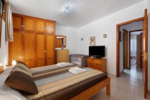 a bedroom with two beds and a flat screen tv at Carpediem Playa La Arena in Puerto de Santiago