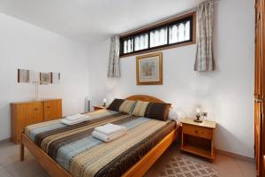 a bedroom with a large bed and a window at Carpediem Playa La Arena in Puerto de Santiago +21 photos