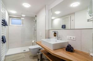 a white bathroom with a sink and a toilet at Ferienwohnung Behling in Frickingen +23 photos
