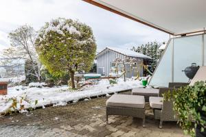 a patio with a table and chairs in the snow at Ferienwohnung Behling in Frickingen