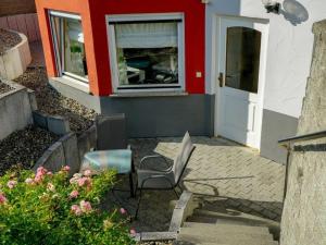a house with two chairs and a window and a door at Ferienwohnung Roth in Frickingen +2 photos