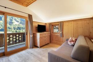 a living room with a couch and a large window at Steineggerhof in Valle Di Casies