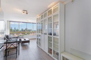 a room with white cabinets and a table and a chair at Apartamento Yumbo Maspalomas in Maspalomas
